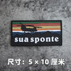 A black badge featuring a silhouette of a helicopter over mountains and the text sua sponte on a gray concrete background.