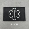 Black fabric patch with a white medical cross symbol embroidered on it