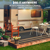 A beige RV is parked next to an outdoor patio rug on a wooden deck, with a white metal chair and table nearby.