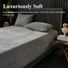 A luxurious gray velvet bedding set featuring a sheet and pillows on a bed.