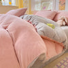 A pink and gray cozy milk velvet duvet cover set displayed on a bed with soft pillows.