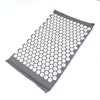 A gray acupressure relief mat with numerous white, circular bumps for pain and stress relief.