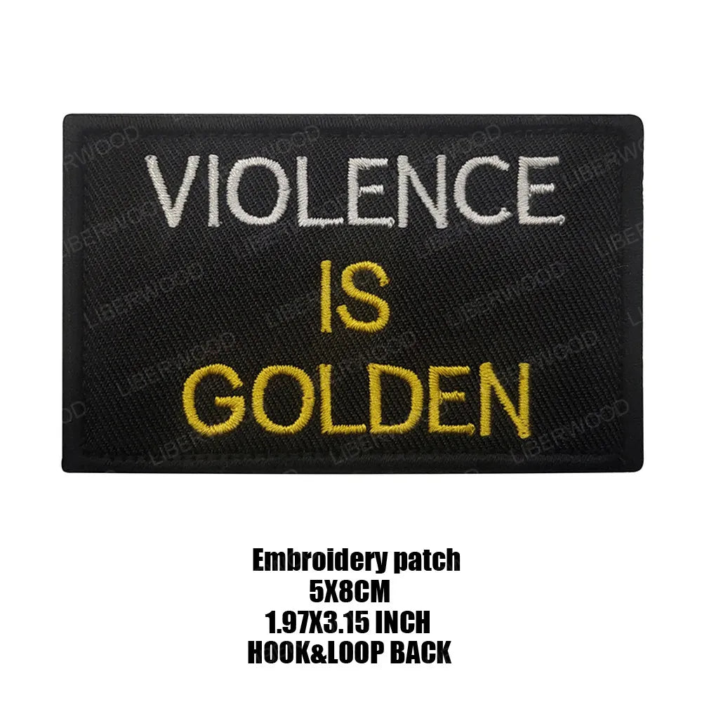 Black embroidered patch with yellow text that reads Violence is Golden