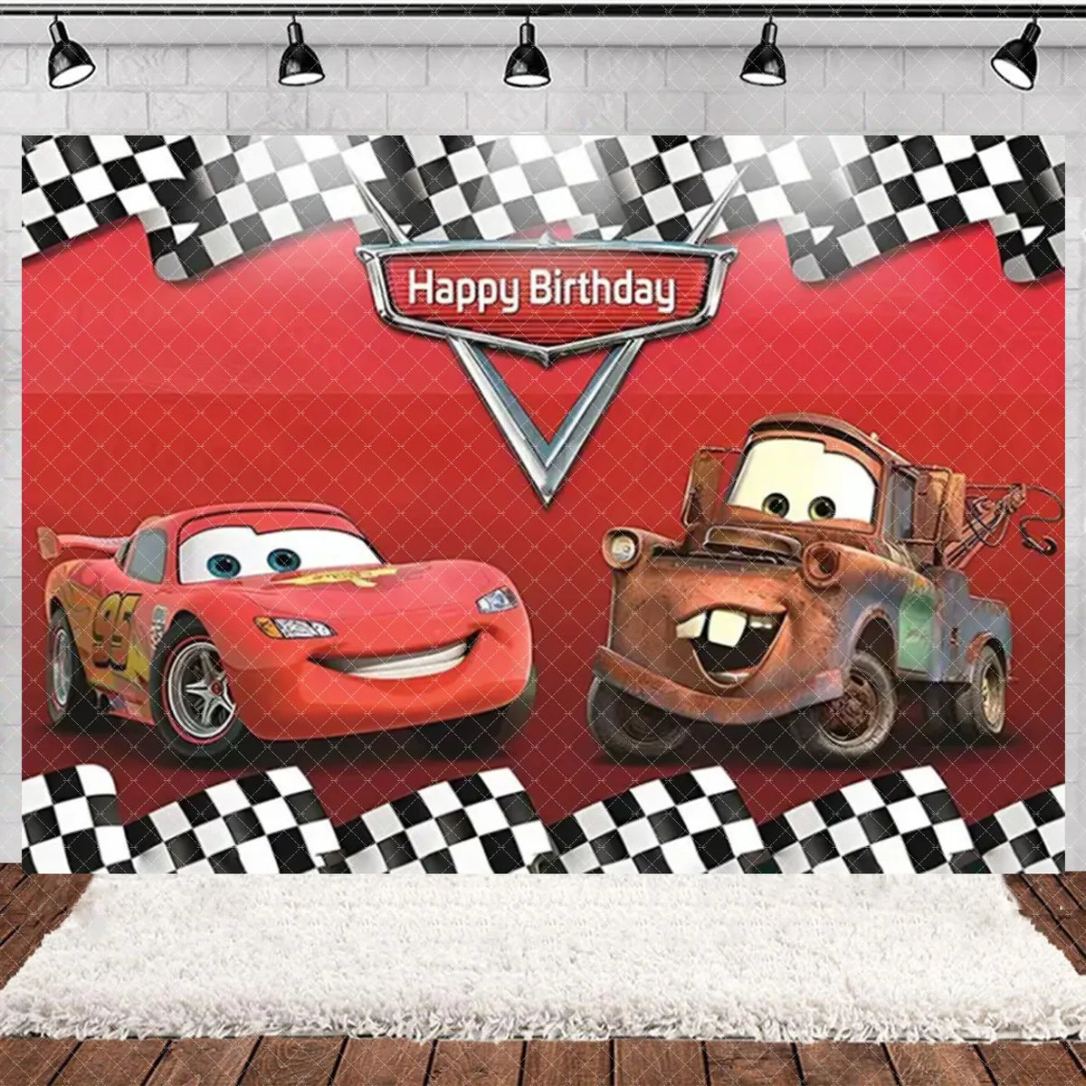 A birthday party backdrop featuring cars from Cars with a checkered pattern and a happy birthday sign.