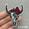 Black and white embroidered iron-on patch of a bull skull with red and blue floral accents