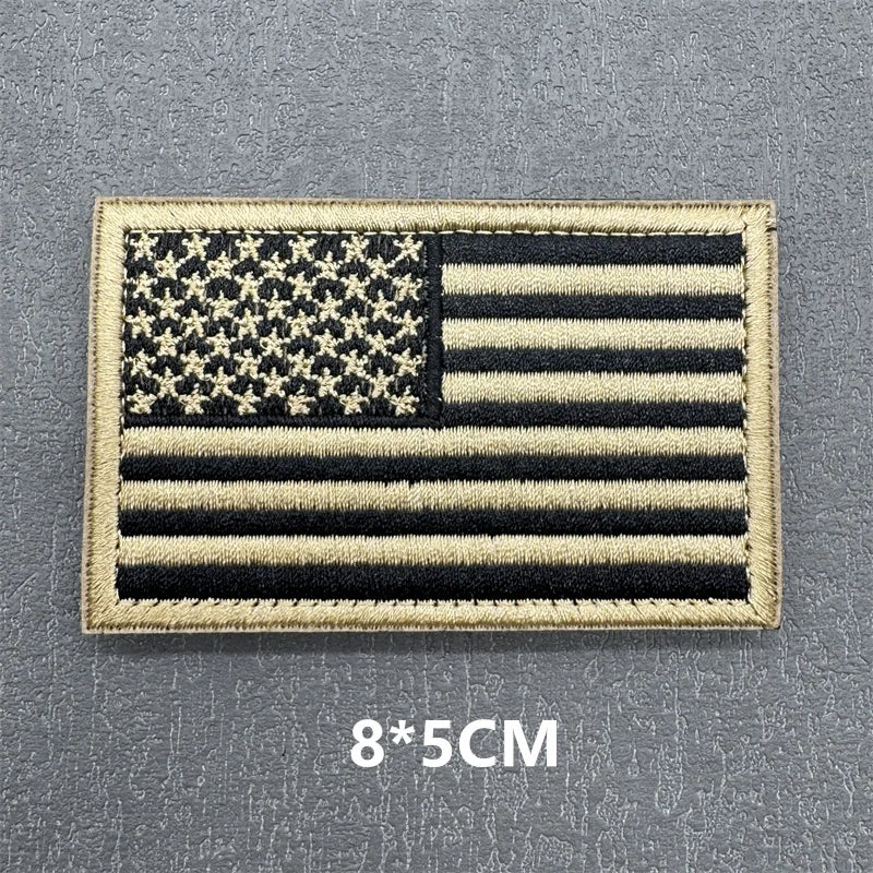 A rectangular USA flag patch featuring stars and stripes with a gold embroidered border.