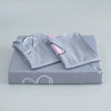 A gray bedding set featuring a duvet cover and pillowcases with pink heart prints.