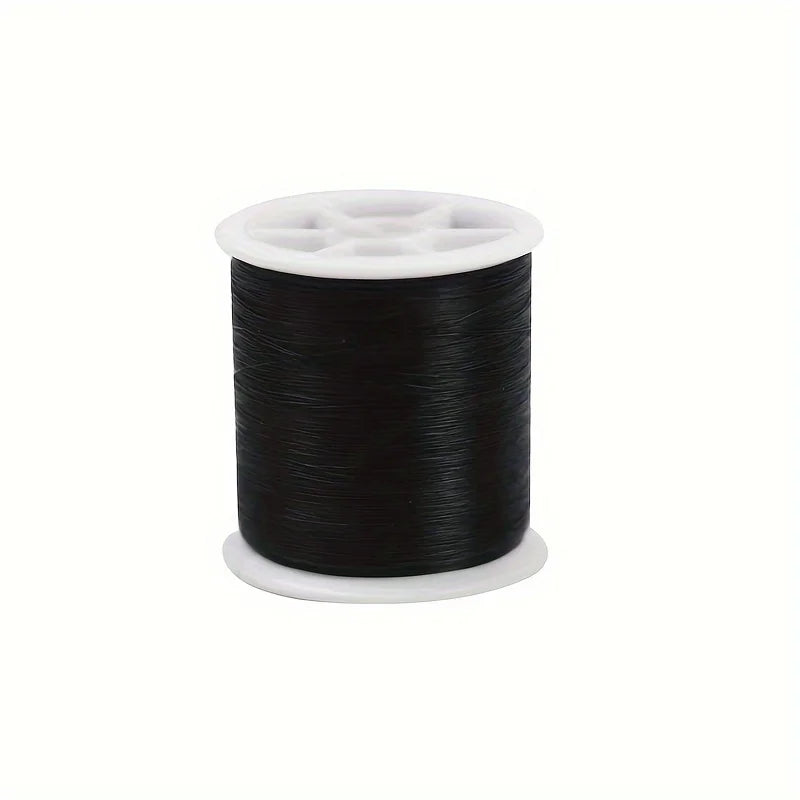 A spool of black invisible nylon sewing thread with a white core and plastic bobbin visible.