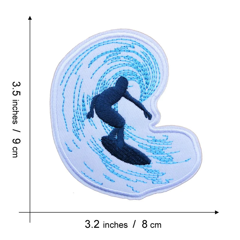 A white embroidered patch featuring a dark silhouette of a person surfing on a blue wave pattern.