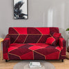 A deep red and maroon patterned elastic sofa cover protector displayed on a gray wall.