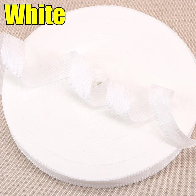 White iron-on hem tape for pants and jeans rolled up on a beige surface