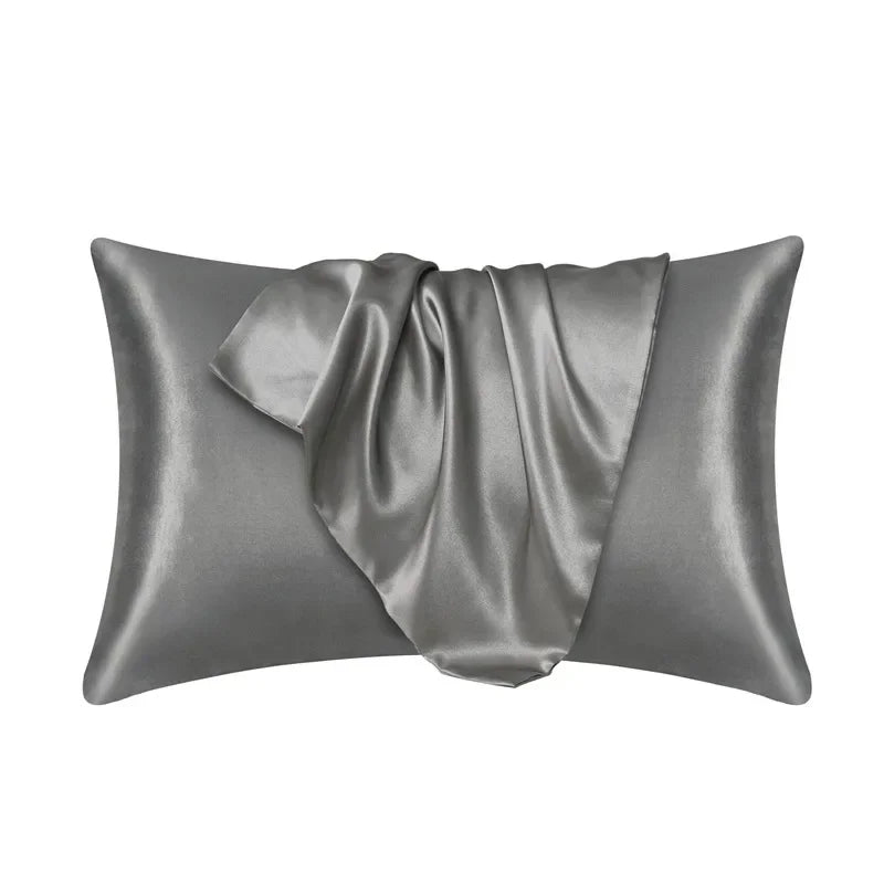 A smooth, gray silk pillow cover draped elegantly on a white background.