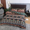 A patterned boho geometric duvet cover set featuring earthy tones and intricate tribal designs on a bed.