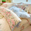 A set of lavender print duvet covers and pillowcases featuring floral patterns and a white teddy bear pillow.