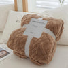 A fluffy brown throw blanket is presented with a gift tag on a white surface.