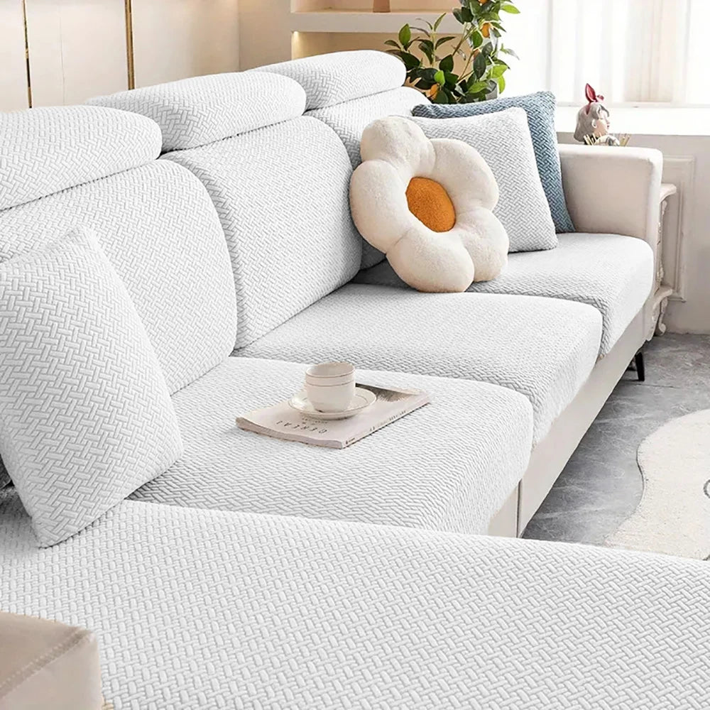 A white thick jacquard sofa seat cushion cover with decorative pillows and a natural light background.