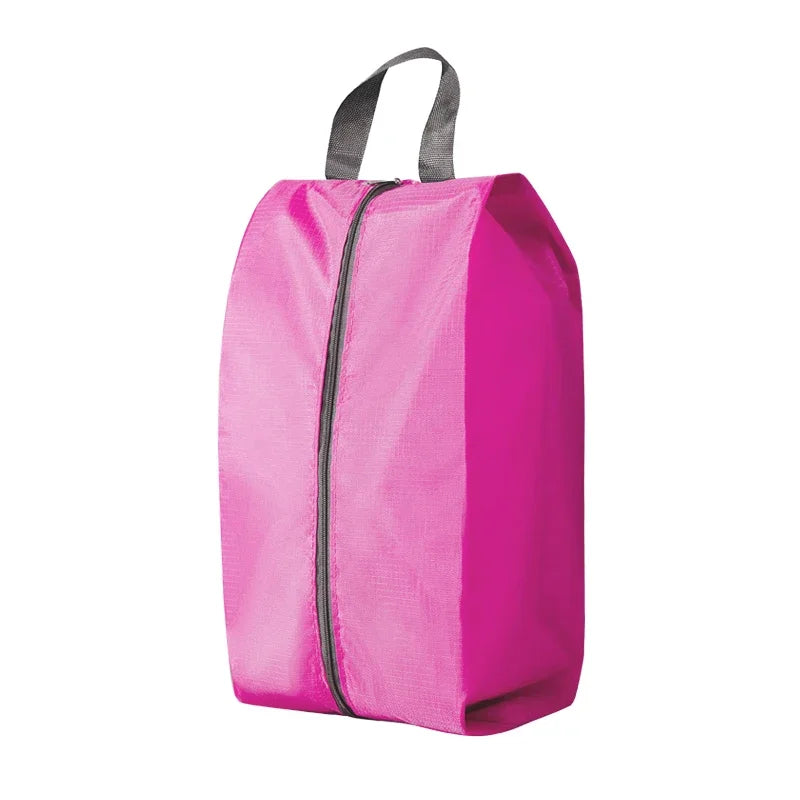 A bright pink durable foldable shoe and travel organizer bag with a black zipper and gray carrying straps.