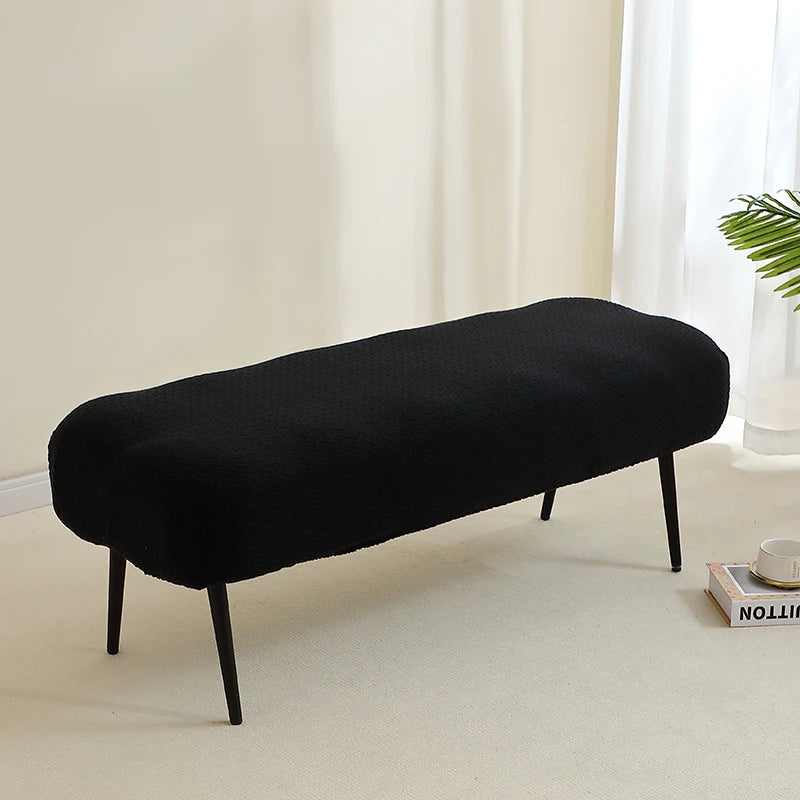 A black elastic jacquard bench cover used as protection for a piano, dining, or entryway seat.