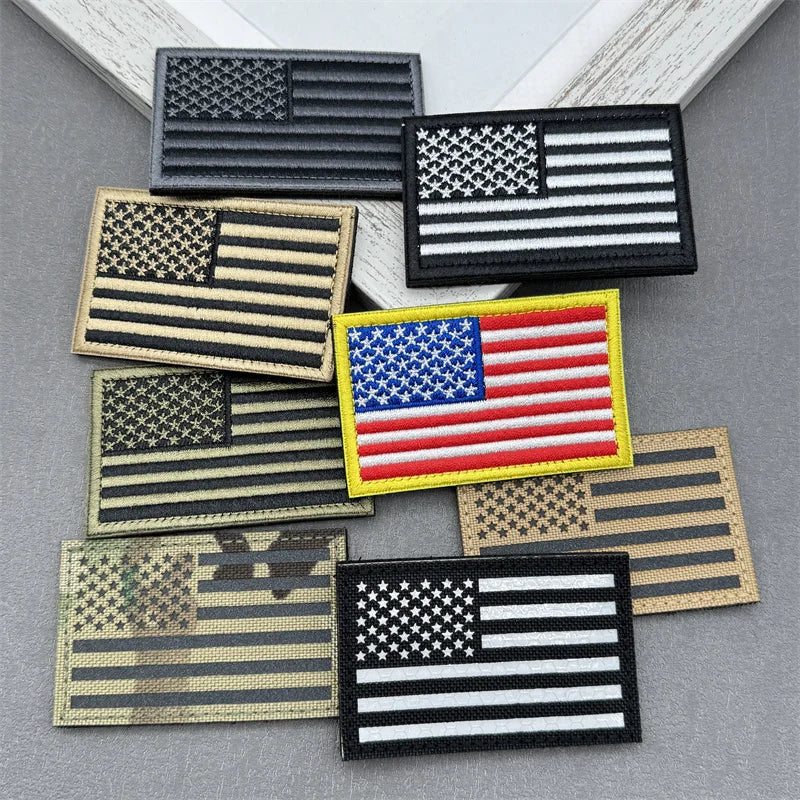 A collection of USA flag tactical reflective patches with hook and loop backing in various designs and colors.