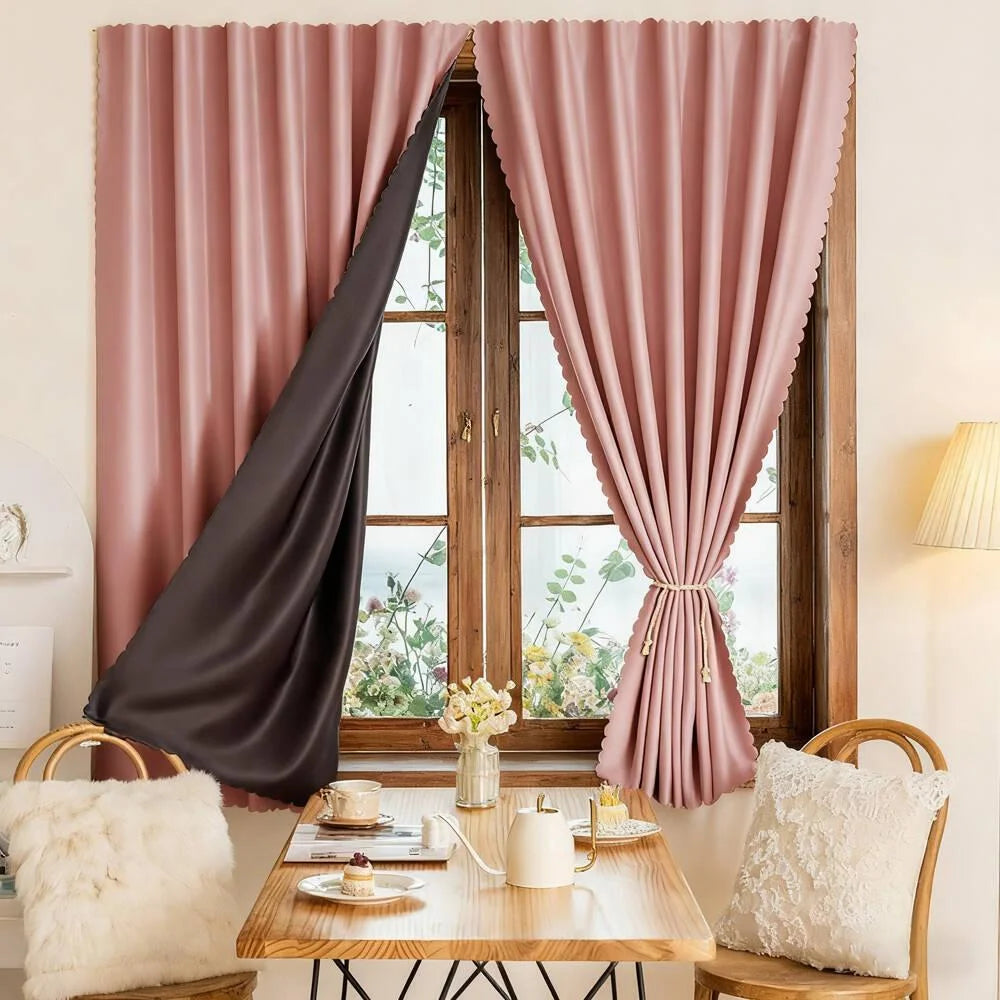 Pink sheer curtains framing a window with greenery and a wooden table and light fabric accents