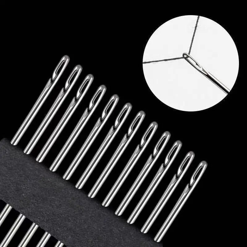 A close-up view of a set of stainless steel self-threading sewing needles against a black background.