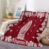 A deep red tapestry blanket featuring white floral and star patterns with a stylized owl design.