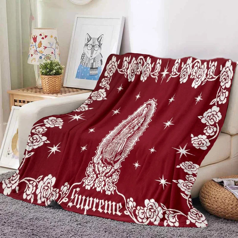 A deep red tapestry blanket featuring white floral and star patterns with a stylized owl design.