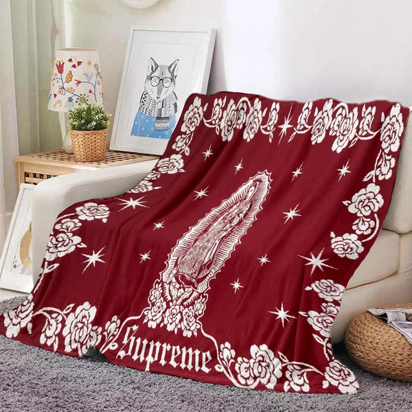 A deep red tapestry blanket featuring white floral and star patterns with a stylized owl design.