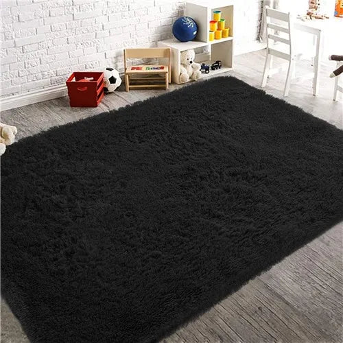 A thick black luxury velvet anti-slip floor mat placed on a wooden floor next to a white brick wall and storage shelves.
