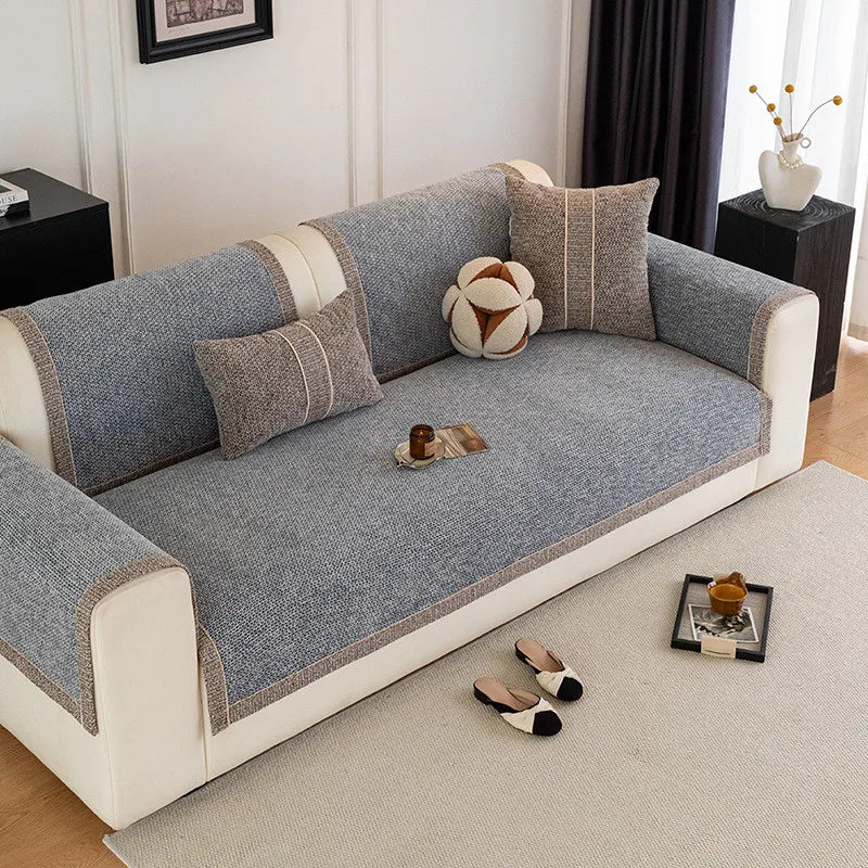 A light gray sofa cushion cover with striped fabric and beige trim sits on a beige rug.