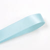 A light blue satin craft ribbon is shown diagonally against a white background.