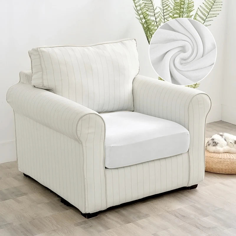 A cream-colored upholstered armchair with vertical stripes and a white cushion sits on a light wood floor.