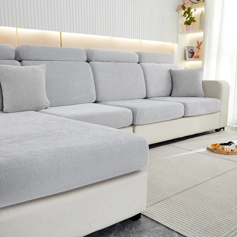 A light gray stretchable chenille sofa cushion cover on a modern sectional sofa with white accents.