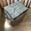 A large gray fabric storage bag with a checkered pattern is resting on a wooden floor.