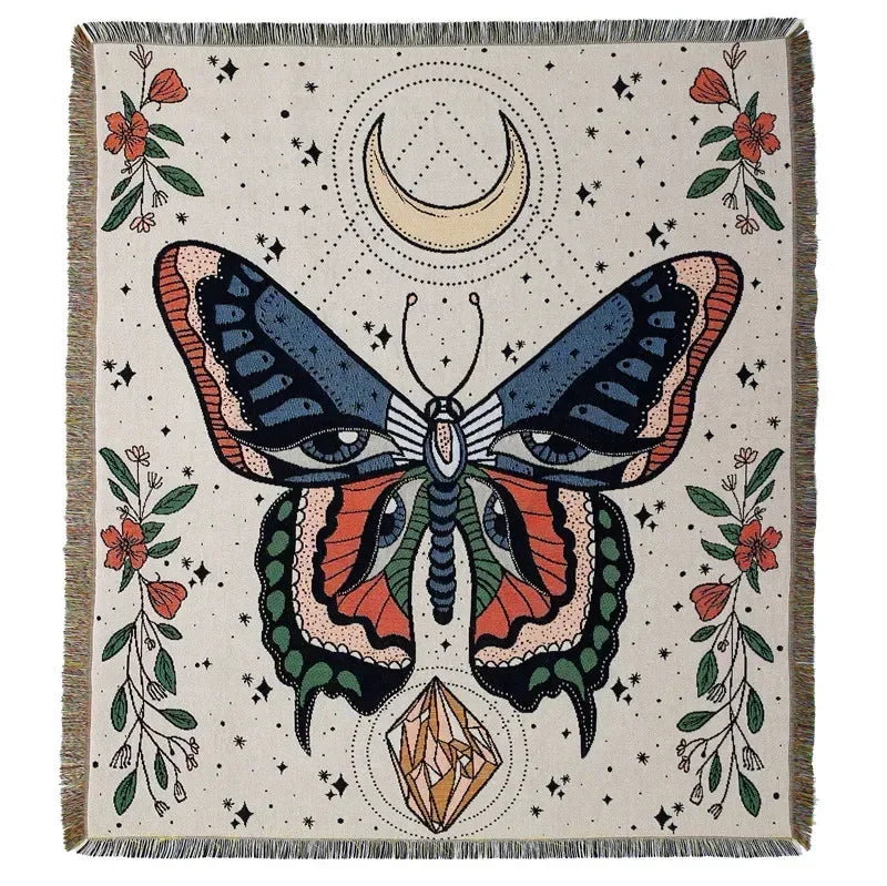 A throw blanket featuring a geometric butterfly design in earthy tones on a light background.