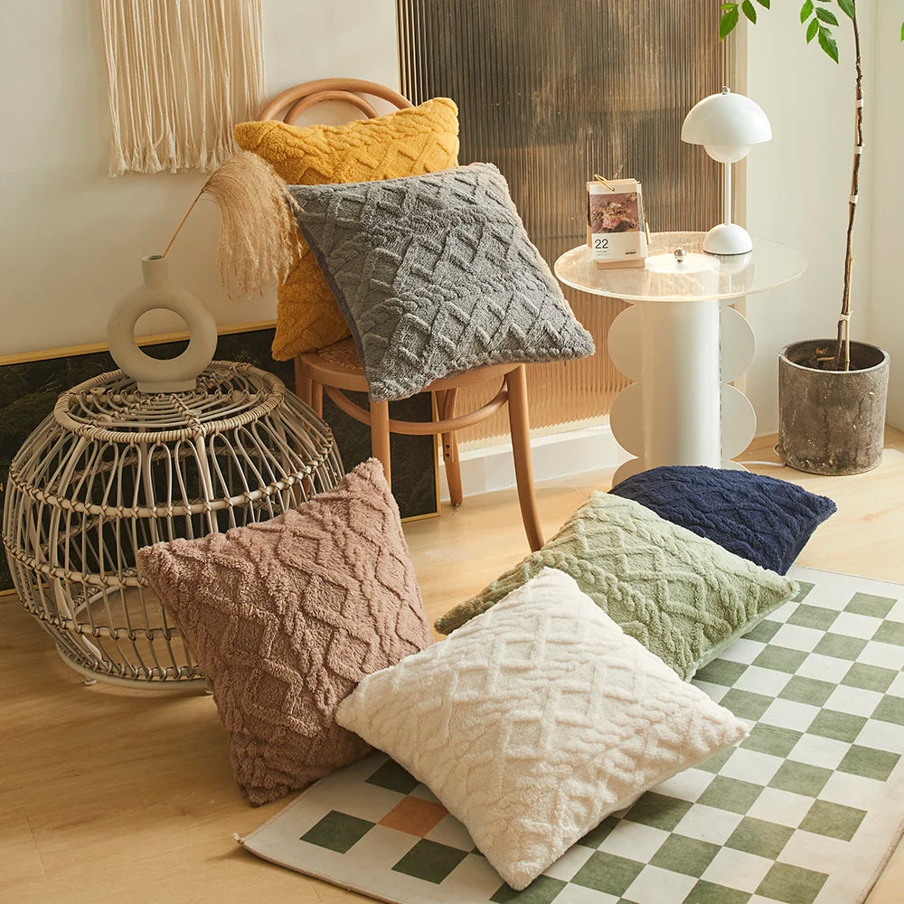 A collection of textured and plaid cushions displayed on a light wooden floor.