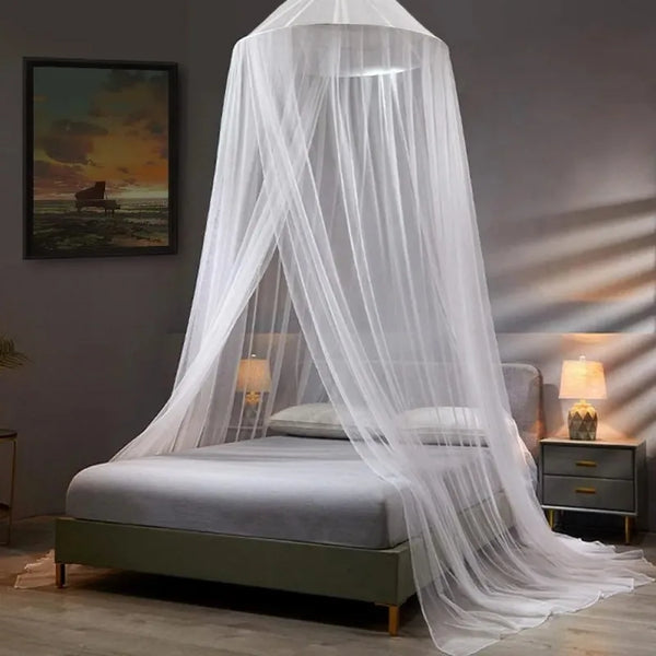 A sheer white dome mosquito net draped over a bed for home protection.