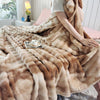 A fluffy tan rabbit fur throw blanket draped over a bed, with a white cup and saucer nearby.