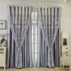 Gray vintage floral blackout curtains hanging in a window with white furniture.