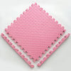 A pink soft interlocking foam play mat with a diamond pattern shown from above.