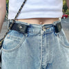 A close-up of a person wearing light wash denim jeans with a black leather belt and chain strap.