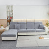 A light gray stretchable chenille sofa cushion cover on a modern sectional sofa in a bright room.