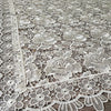 White floral lace tablecloth with intricate openwork pattern.