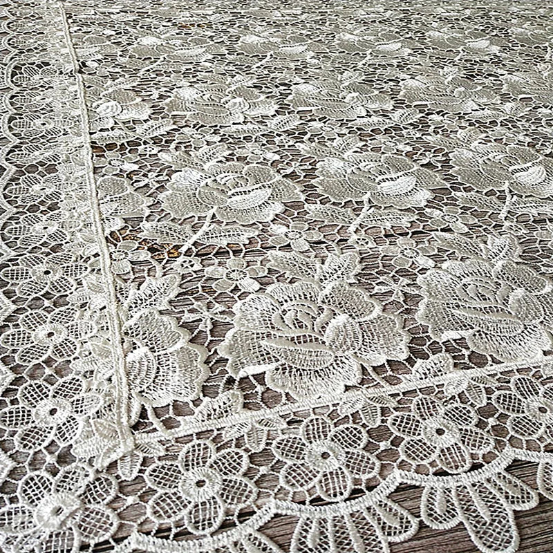 White floral lace tablecloth with intricate openwork pattern.