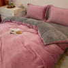A luxurious flannel duvet cover set in dusty rose and gray tones displayed on a bed.