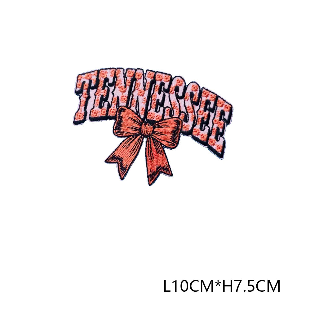 Iron-on embroidered letter patch spelling out TENNESSEE with a peach colored bow
