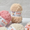 A stack of soft coral velvet yarn balls labeled Smile and 亲妈线 for crafting.