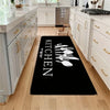 A black non-slip kitchen mat featuring white silhouette illustrations of various kitchen utensils on a light wood floor.