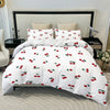 White duvet cover set with a red fruit print featuring cherries on a bed.