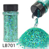 A glass bottle of holographic teal glitter and a pile of loose teal glitter mix.